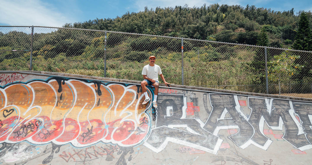 Jack Soren on edge of skate ramp with board next to him