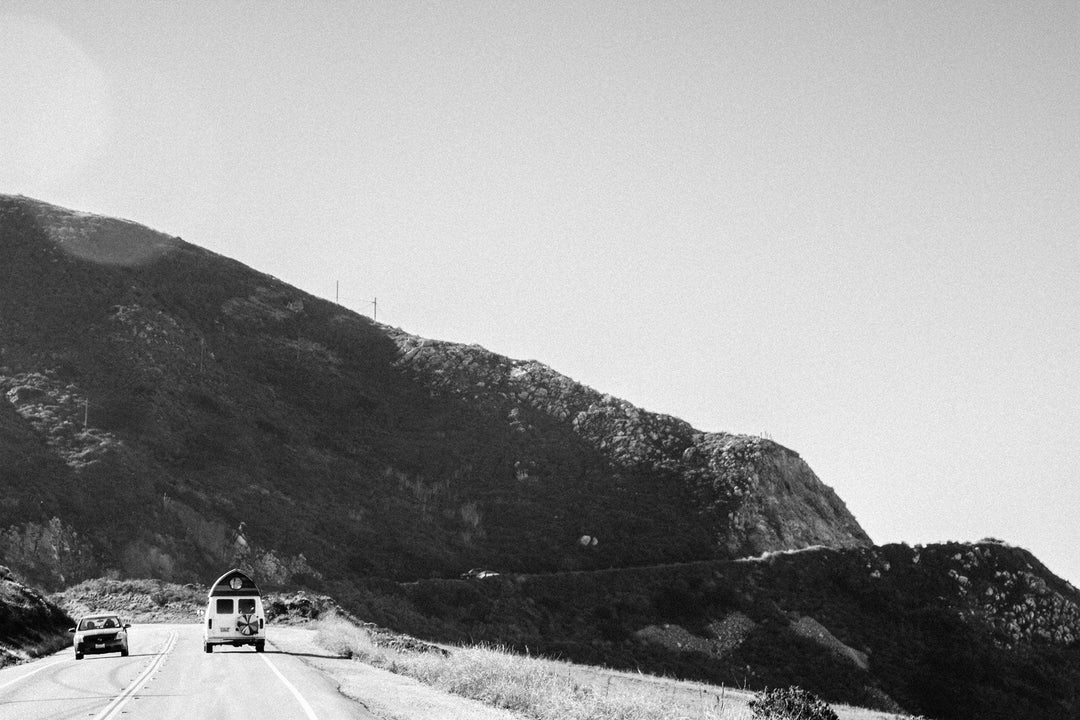 Van on highway with big hill in front of it