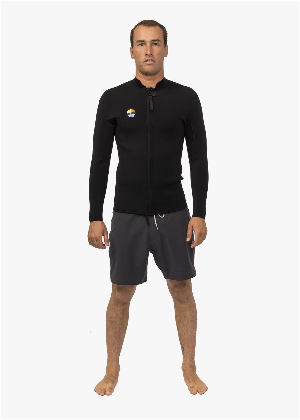 A person standing and facing forward, wearing a black front zip neoprene surfing jacket and dark shorts